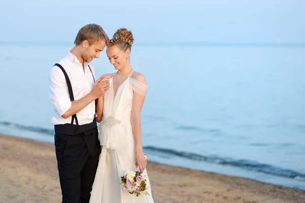 Beach wedding: bride and groom by the sea