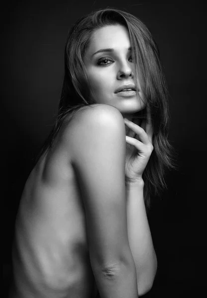 Young topless woman on black