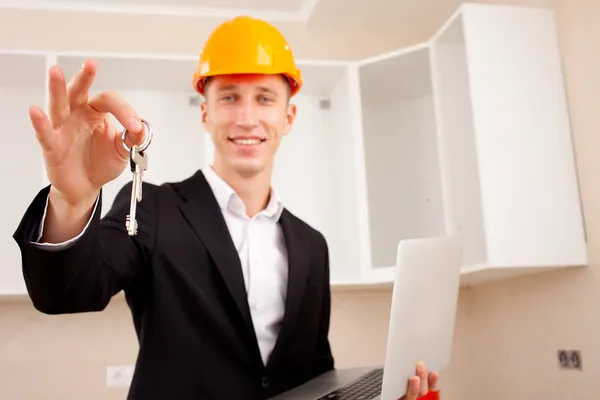 Civil engineer with a laptop gives the keys