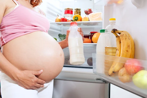 Pregnant woman and refrigerator with health food
