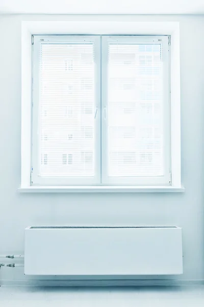 White plastic double door window with radiator under it.