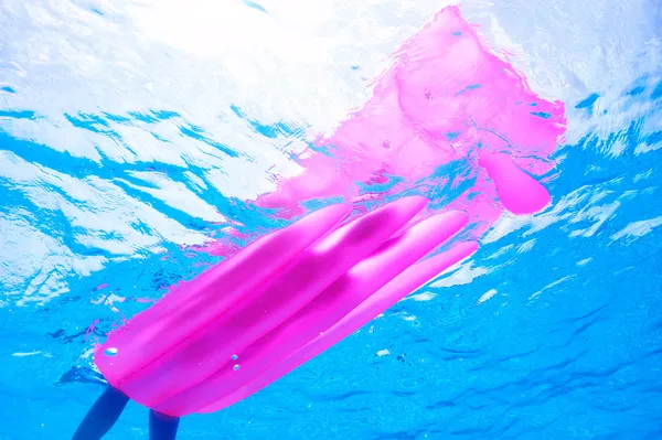 Woman relaxing on inflatable mattress, view from underwater