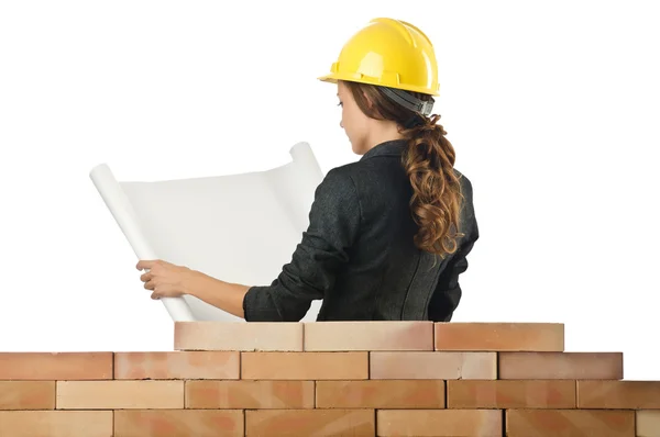 Businesswoman with drawings near brick wall