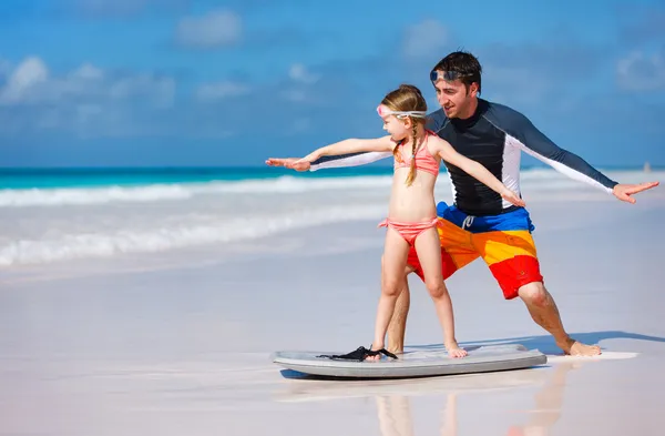Father and daughter practicing surfing