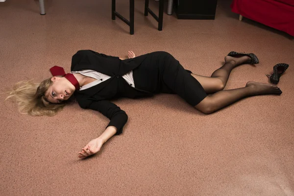 Lifeless business woman lying on the floor (imitation)