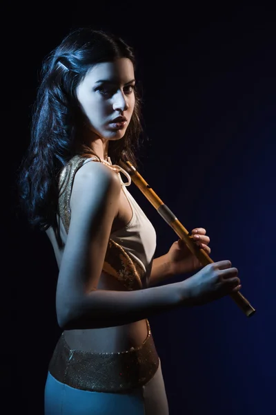 Sensuality brunette with a wooden flute