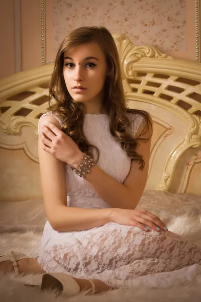 Elegant girl in evening dress in an elegant bedroom