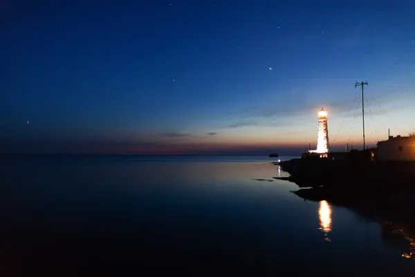 Lighthouse on the water edge at night