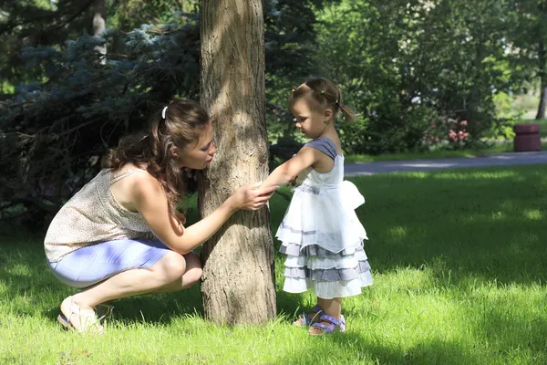 Little girl shows her mother insect bite (in a city park).