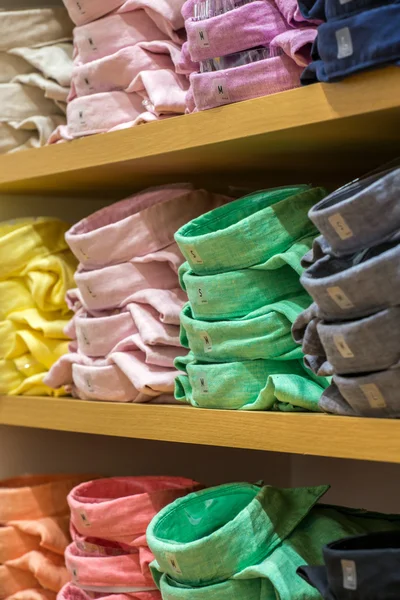 Neat stacks of folded clothing on the shop shelves