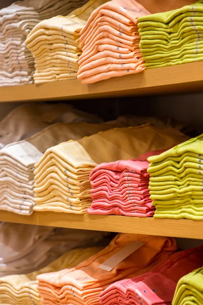 Neat stacks of folded clothing on the shop shelves