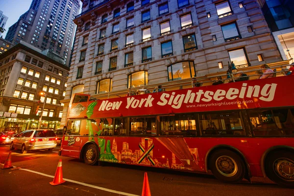 NEW YORK CITY - JUN 8 - Famous Sightseeing red bus at sunset