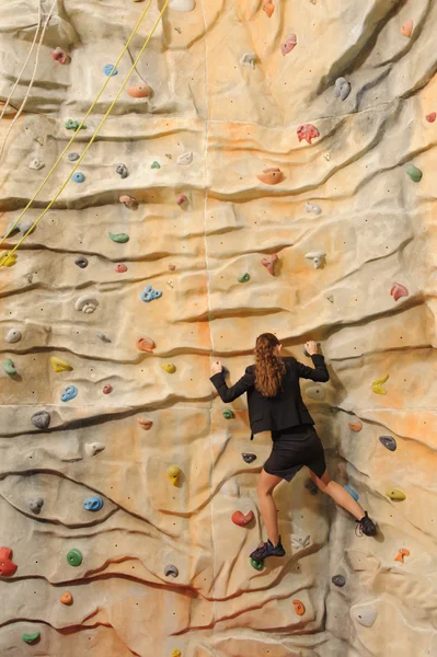 Business woman on rock wall