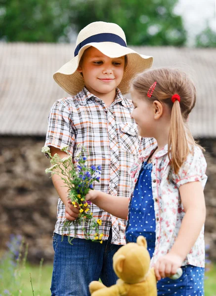 Little boy gives flowers to the little girl