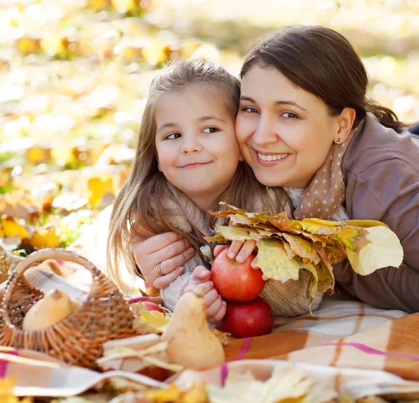 Happy young mother with daughter in autumn park