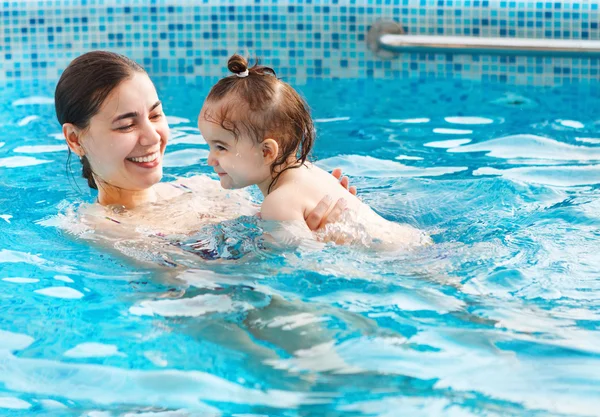 One year baby girl at her first swimming lesson with mother