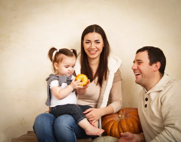 Happy smiling family with pumpkin indoor