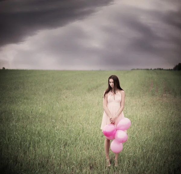 Beautiful young women with pink balloons outdoor