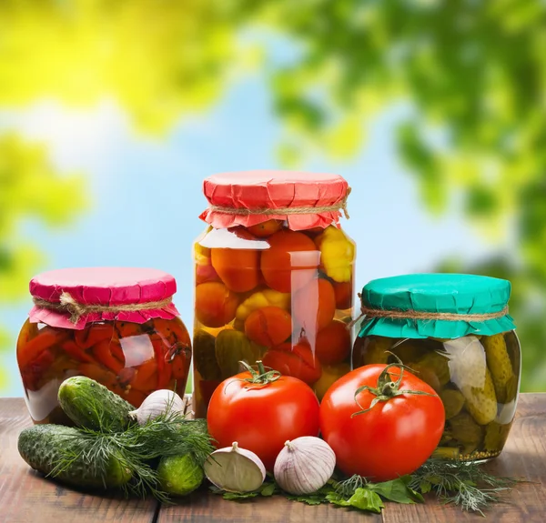 Canned and fresh vegetables on the background of nature