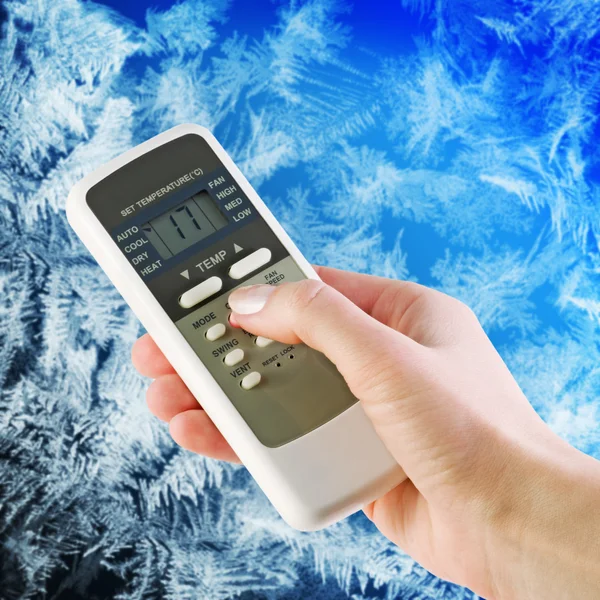 Air conditioner remote control in hand