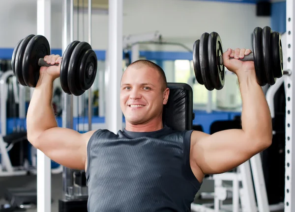 Man with dumbbells in sports club