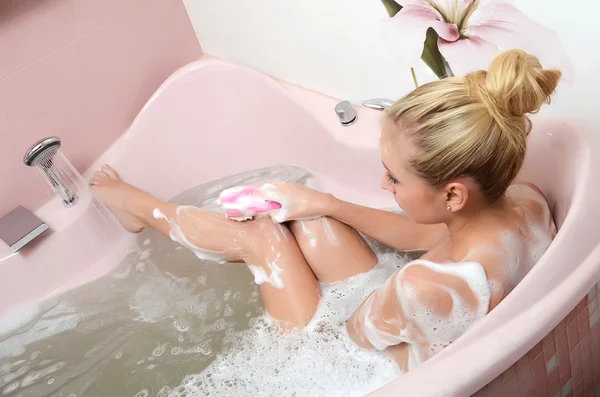 Woman blonde in a bath with foam