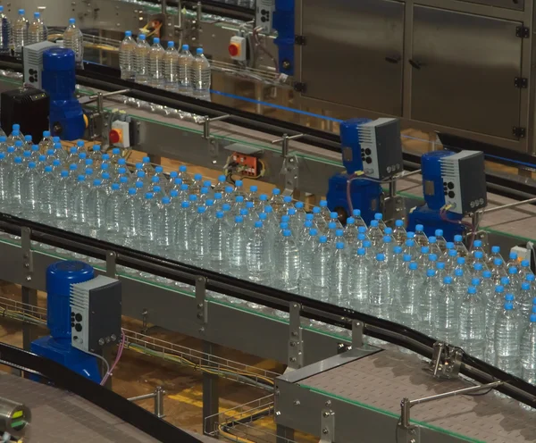 Plastic water bottles on conveyor and water bottling machine ind