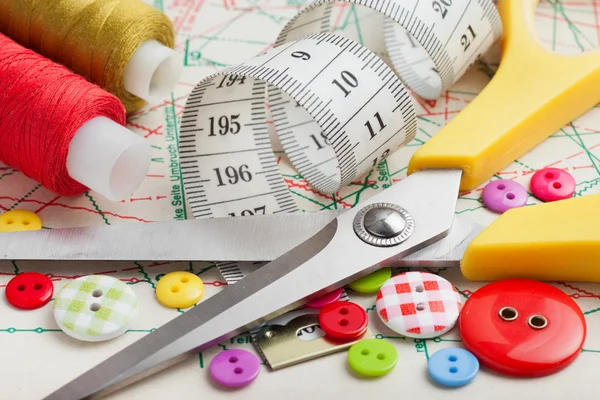 Sewing items: buttons, colorful fabrics, scissors, measuring tap