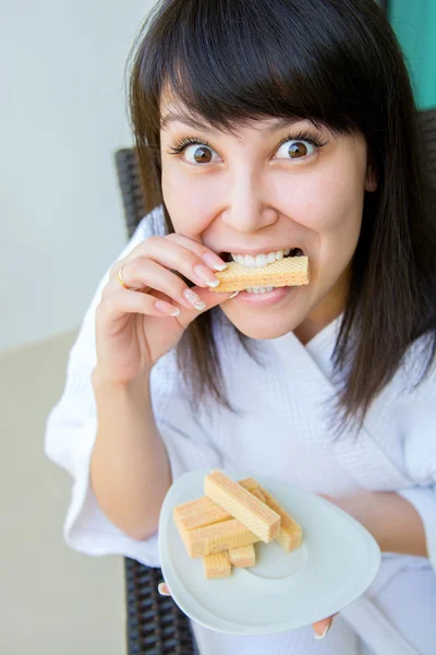 Close-up Portrait of young pretty woman with rage eats wafer