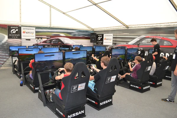 Teenagers drive simulators of racing game at the Nismo G-Drive S