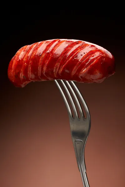 Grilled smoked sausage on a fork