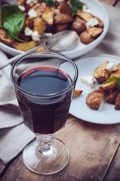 A glass of wine and a baked potato