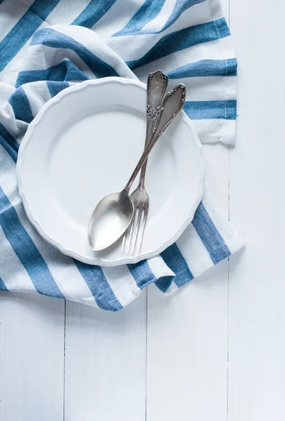Cutlery, porcelain plate and white linen napkin