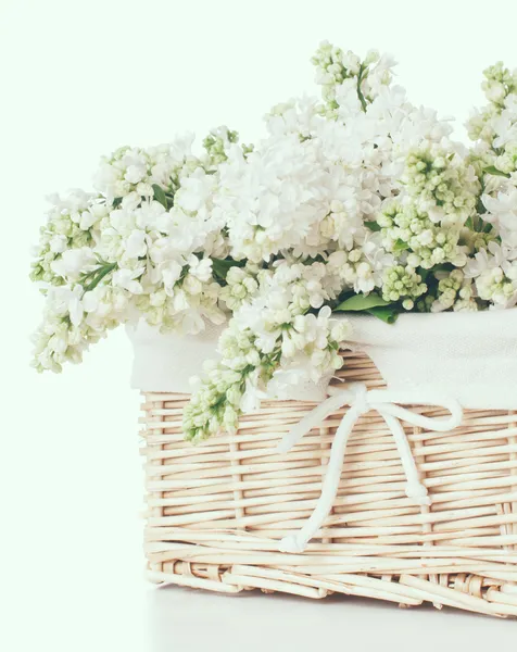White lilac flowers in a wicker basket