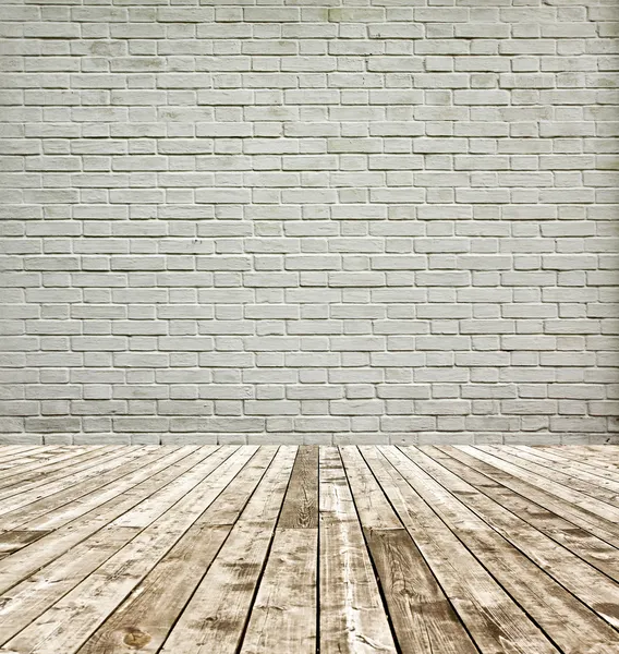 Background of aged grungy textured white brick and stone wall with light wooden floor with whiteboard inside old neglected and deserted empty interior, blank horizontal space of clean studio room