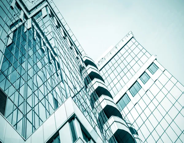 Panoramic and prospective wide angle view to steel light blue background of glass high rise building skyscraper commercial modern city of future. Business concept of successful industrial architecture