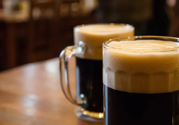 Two glasses of dark beer on table