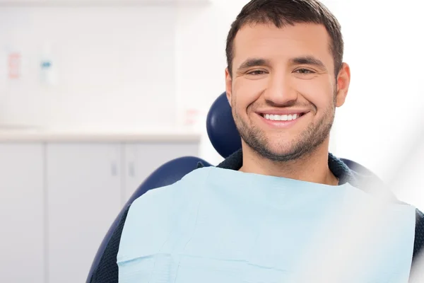 Smiling young man at dentist's surgery — Stock Photo #36578021