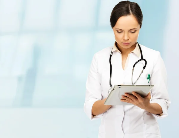 Young brunette doctor woman taking notes on tablet pc