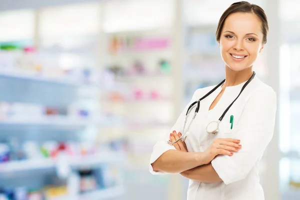 Young positive brunette doctor woman in drug store