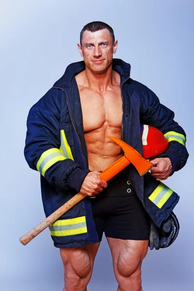 Portrait of handsome man posing on black background in fireman c