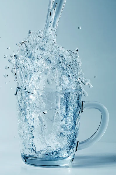 Pouring water into a glass mug