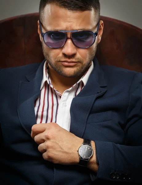 Frowning businessman wearing sunglasses