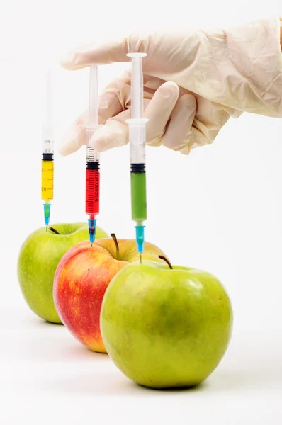 Three apple with syringes injecting colorful liquid