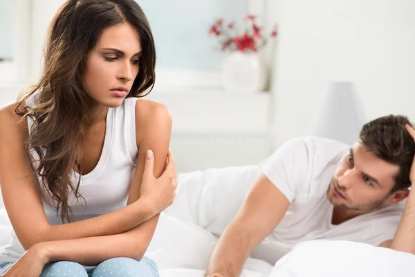 Unhappy young couple in bedroom