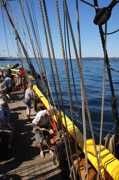The crew sets the sails of the Lady Washington