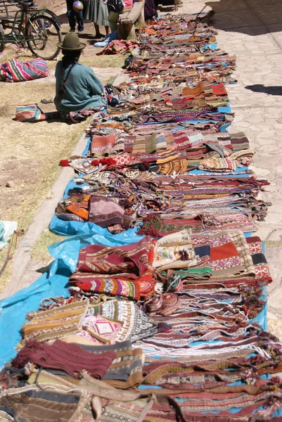 Quechua Indian woman selling colorful handmade blankets