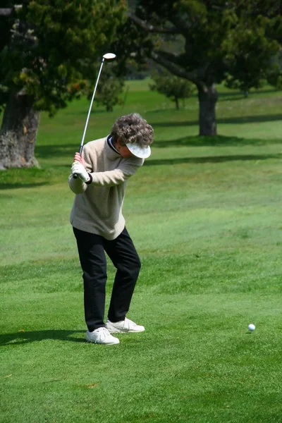 Woman golfer teeing off