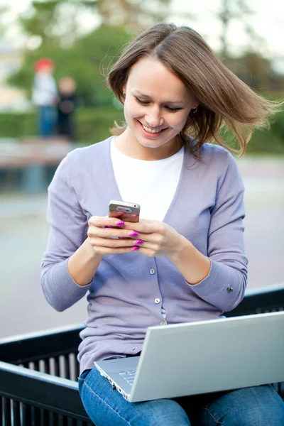 Young woman with laptop and cell phone