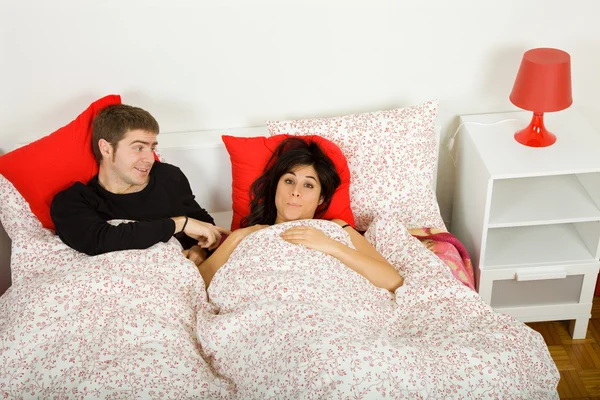 Young couple in bed, studio picture